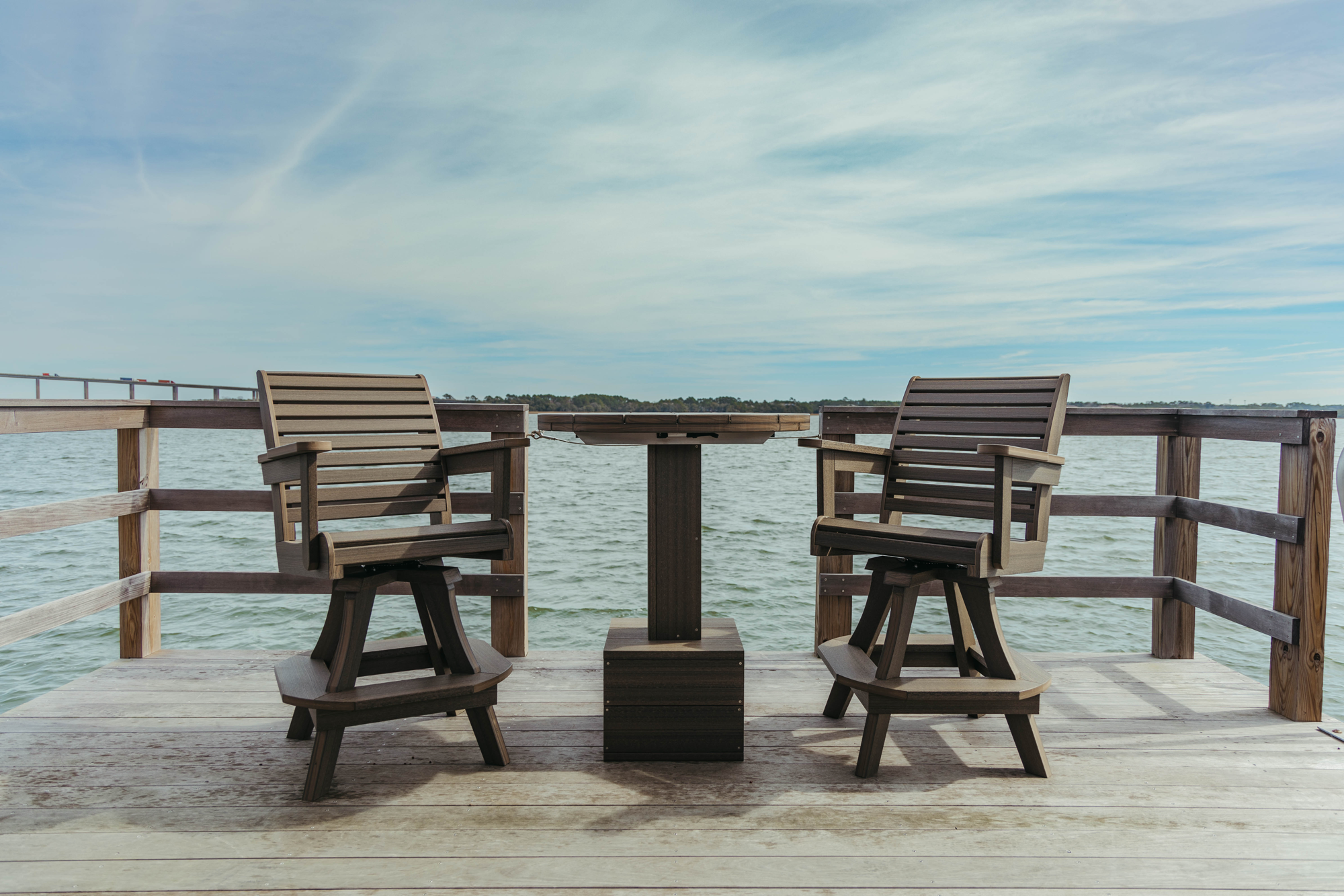 Two Coastal High Tide Swivel Chairs sit on a dock