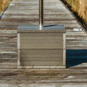 A Box Anchor Base sits on a dock with a Capri Palmetto Umbrella. 