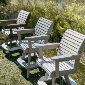 Three High Tide Outdoor Bar Chairs poolside in a row, showing variations of color options. 