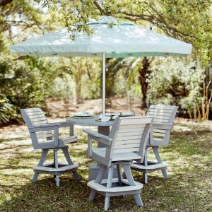 Palmetto High Tide Patio Package in Driftwood and Seashell color with a Sea Palmetto umbrella sit in the shade of an oak tree in a backyard.