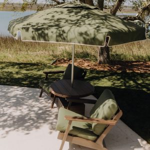Palmetto Low Tide Patio Package with Brazilian walnut poly table, two Bourbon Chairs, and a Sunbrella® Fern canopy.